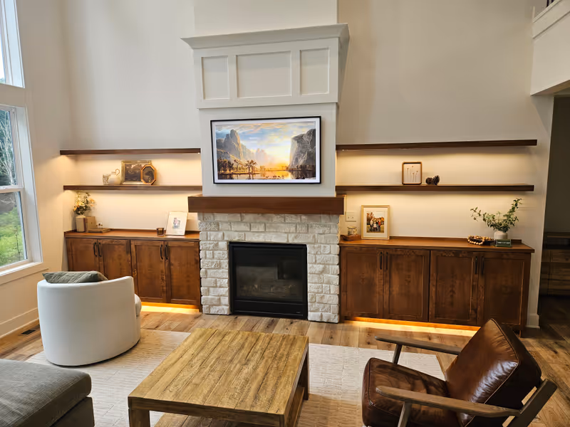 Custom built-in cabinets with walnut shelves, stone fireplace surround, and integrated LED accent lighting